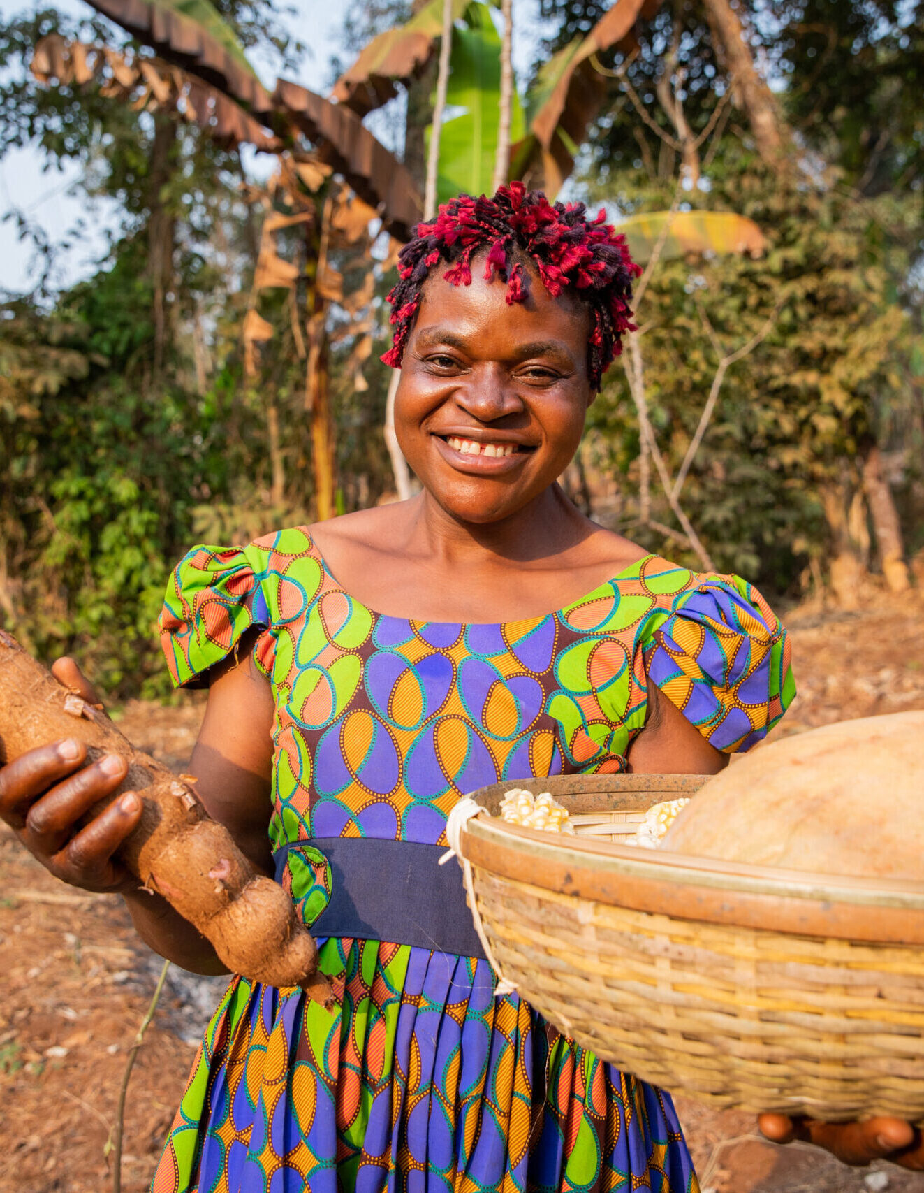 A smiling peasant woman with her harvest basket in the fields, small business owner in Africa