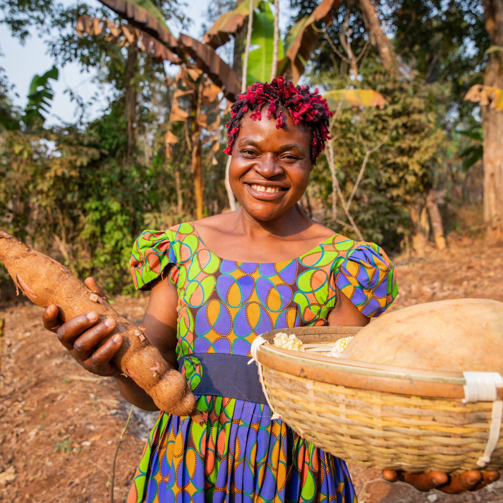 A smiling peasant woman with her harvest basket in the fields, small business owner in Africa